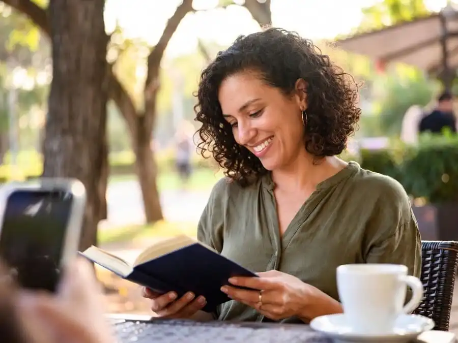 Pessoa vivendo momento offline com alegria, celular de lado, simbolizando equilíbrio e autocuidado digital.