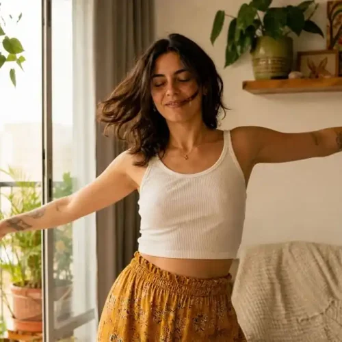 Pessoa em casa começando a dançar com expressão de alívio e leveza, luz natural suave em ambiente brasileiro, simbolizando redução da ansiedade através do movimento corporal.