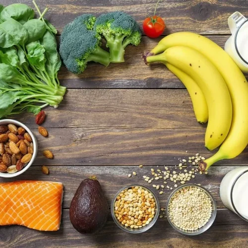 Mesa rústica com vegetais, peixes, frutas, grãos e laticínios ricos em sais minerais.